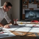 Architect reviewing blueprints with tools and plans