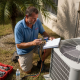 HVAC technician servicing unit in Florida sun