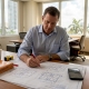 Engineer reviewing building blueprints in project office