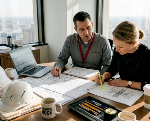 Forensic engineers discussing project documents in office